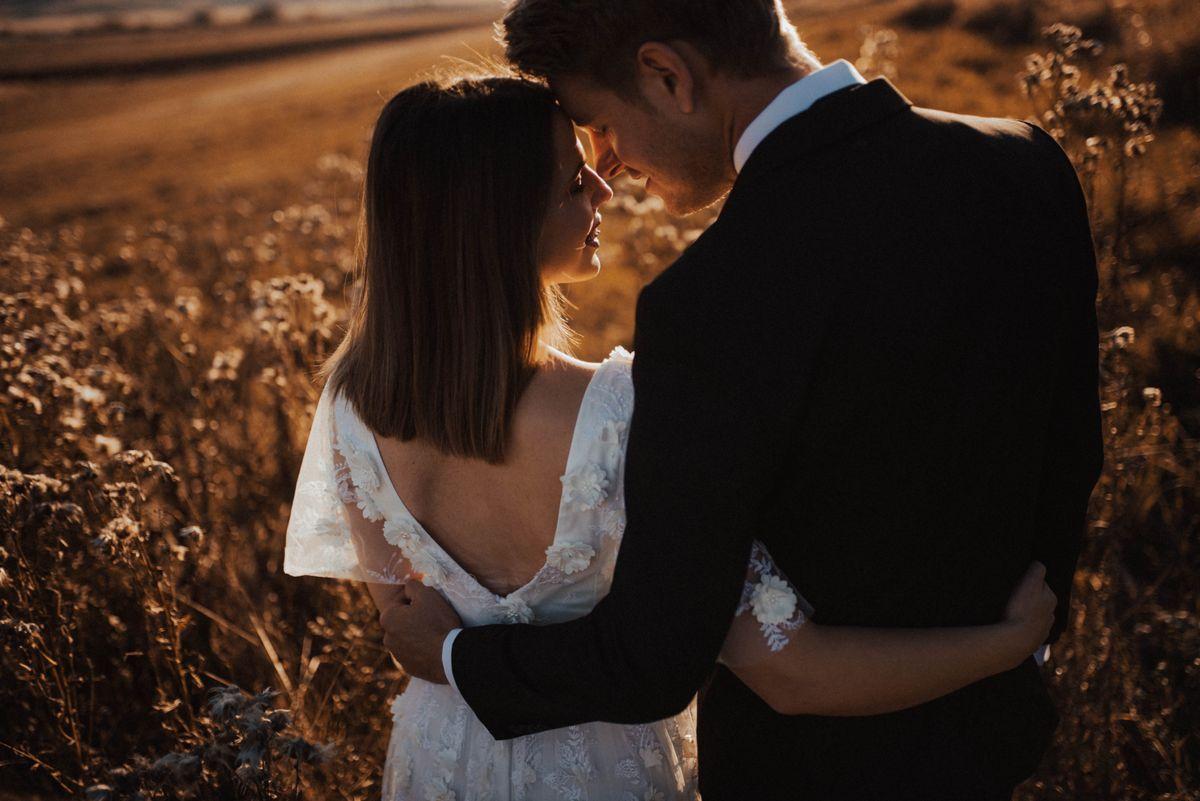 Bride and groom embracing in a golden field